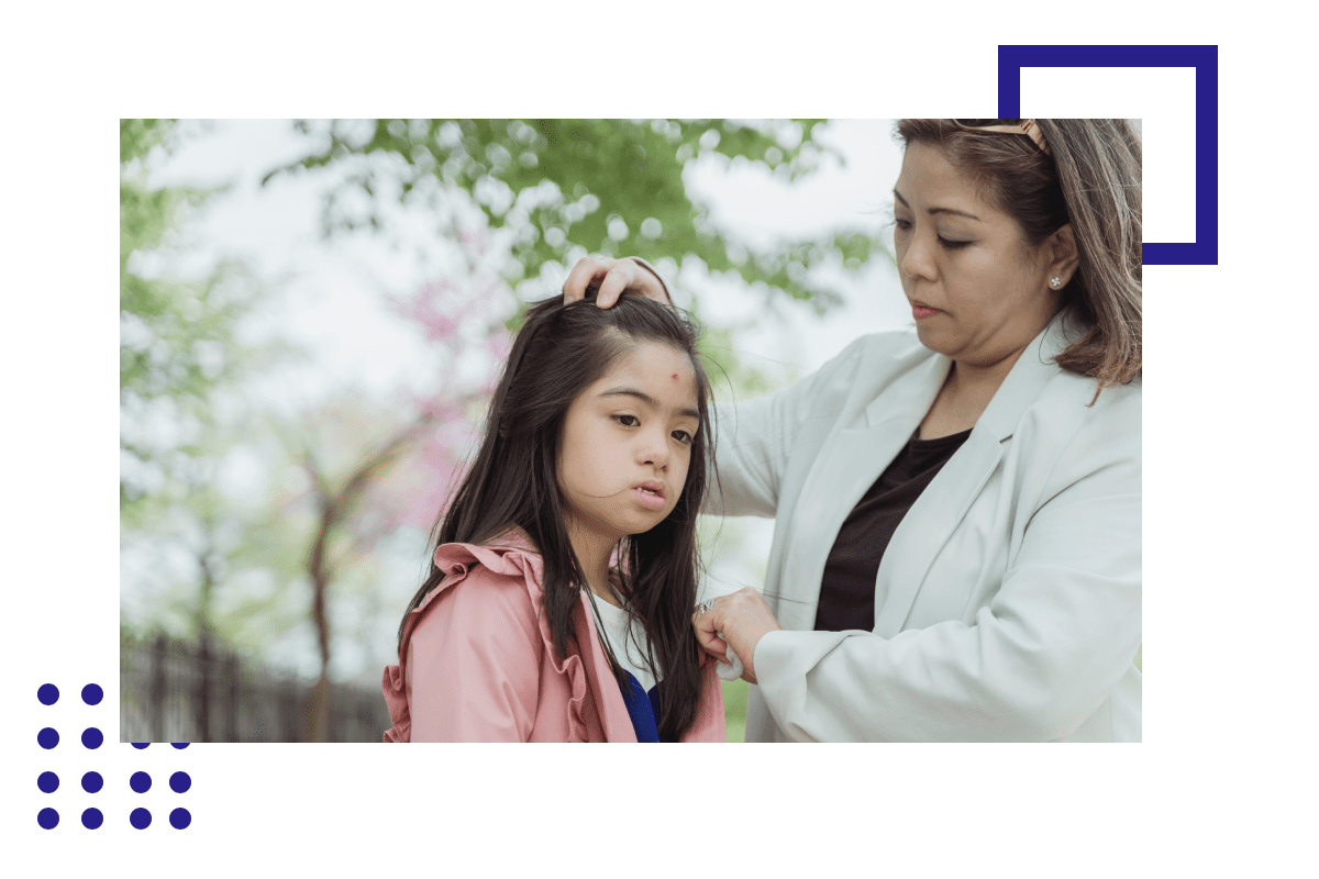 A woman is combing the hair of a young girl.